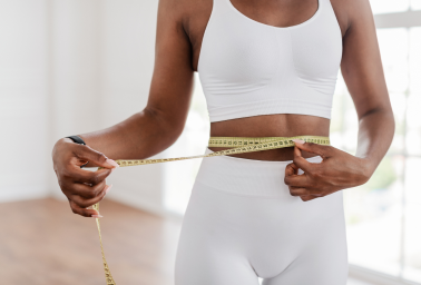 Person measuring their waist representing GLP-1 weight management